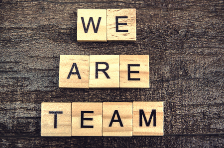 we are team word in wood cube on wood backgroundの写真素材