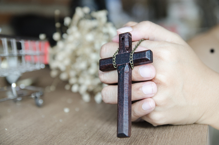 wooden cross in the hand with focus on the crossの写真素材
