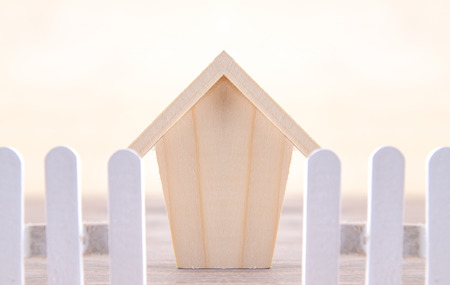 wood home model and fence on creamy backgroundの写真素材