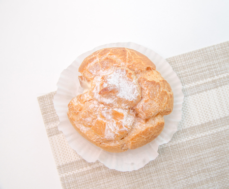 Profiteroles stuffed with pastry cream on white desk in cafe
