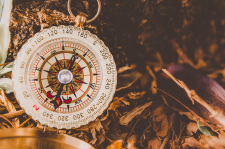 Antique brass compass over wooden background (vintage)の写真素材