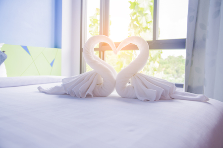 Swan shape Bath towels on the bed of hotel bedroomの写真素材