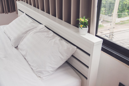quilt bed  white pillows on white bed in bedroomの写真素材