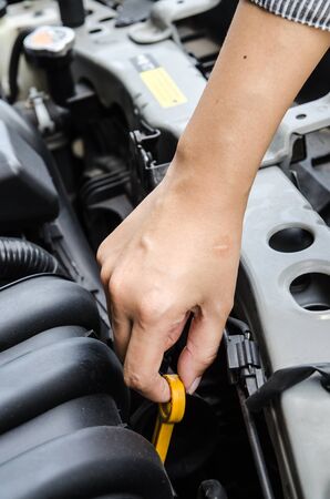 Check the condition of the car engine, repair or maintenance concept. Professional car mechanic fixing a car engine in auto repair workshop service. Selective focus.の写真素材