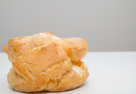 Profiteroles stuffed with pastry cream on white desk in cafe の写真素材