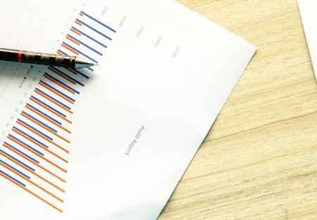 Preparing report. Blue graphs and charts. Business reports and pile of documents on gray reflection background.の写真素材