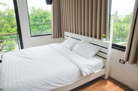 quilt bed  white pillows on white bed in bedroomの写真素材