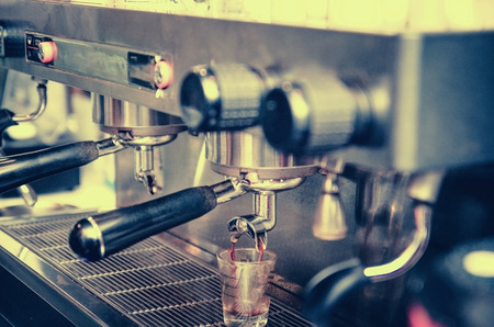 prepares espresso in his coffee shop ; close-up , vintage tone の写真素材