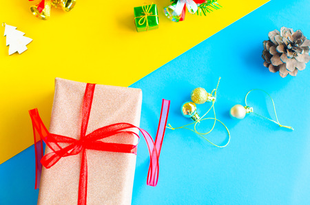 golden gift box and red ribbon on color backgroundの写真素材