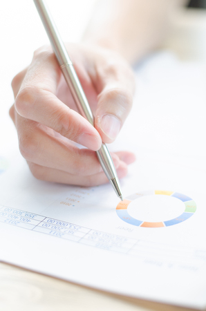 woman hand with pen and business reportの写真素材