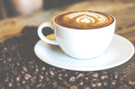 Coffee cup on wood table with coffee beanの写真素材