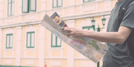 Young man traveler with map on street building backgroundの写真素材