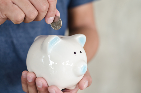 woman hand putting money bank note dollar into piggy for saving money wealth and financial concept.の写真素材