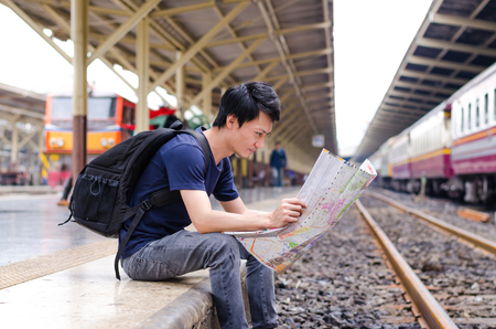 Young man traveler with map on street building backgroundの写真素材