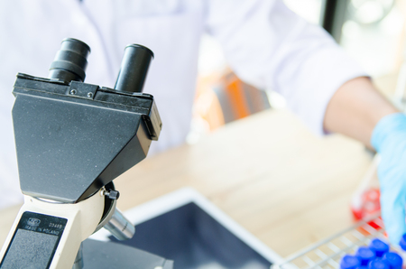 Young scientist looking through a microscope in a laboratory. Young scientist doing some research.の写真素材