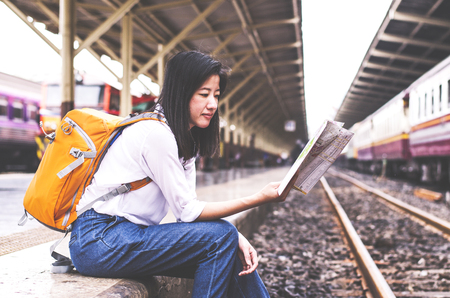 young women hold map on hand in train stationの写真素材