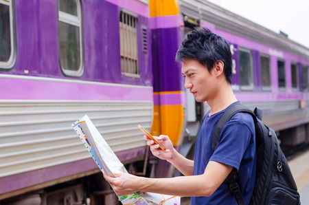 Young man traveler with map on street building backgroundのeditorial素材