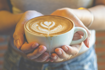 woman holding a cup of coffee in the morning, selective focus.の写真素材