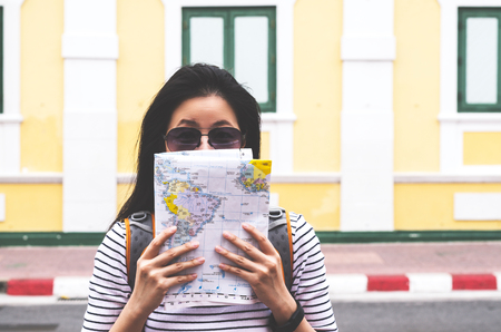 Young traveler with map on street building backgroundの写真素材