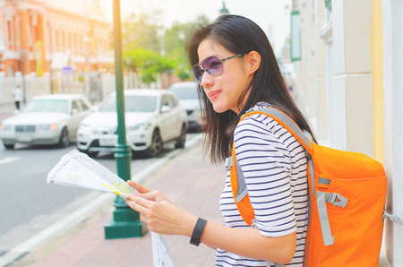 Young women traveler with map on street building backgroundの写真素材