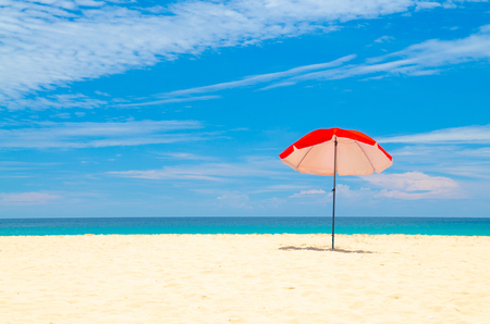 red umbrella beach white sand and blue skyの写真素材