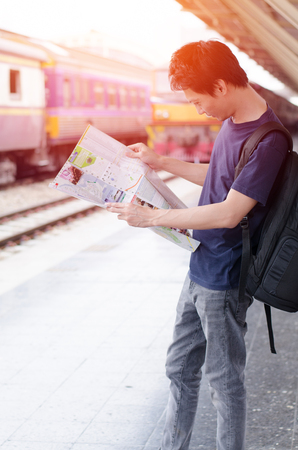 Young man traveler with map on street building backgroundの写真素材