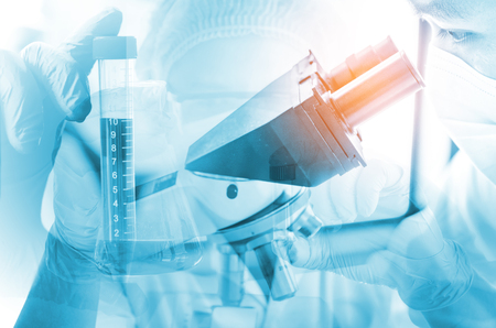 Young scientist looking through a microscope in a laboratory. Young scientist doing some research.の写真素材