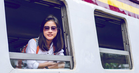 Girl wearing backpack , waiting for a train. Traveling in Bangkok Thailand. Travel conceptの写真素材