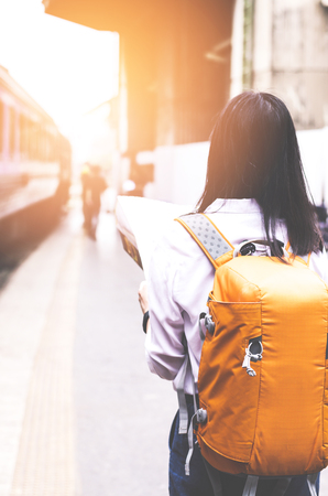 young women hold map on hand in train stationの写真素材