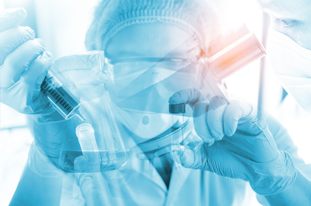 Young scientist looking through a microscope in a laboratory. Young scientist doing some research.の写真素材