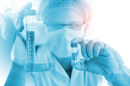 Young scientist looking through a microscope in a laboratory. Young scientist doing some research.の写真素材