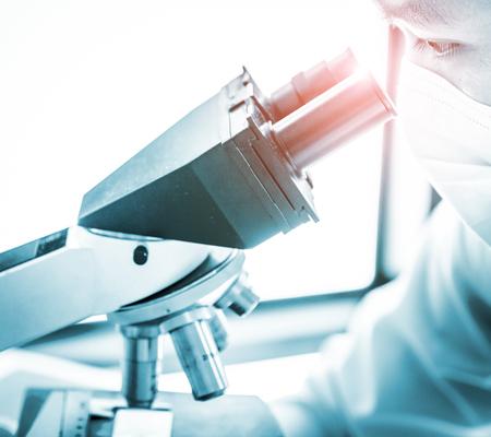 Young scientist looking through a microscope in a laboratory. Young scientist doing some research.の写真素材
