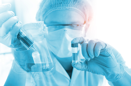 Young scientist looking through a microscope in a laboratory. Young scientist doing some research.の写真素材