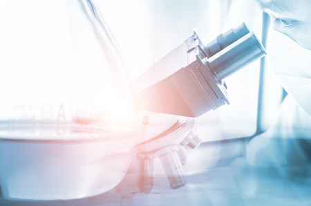 Young scientist looking through a microscope in a laboratory. Young scientist doing some research.の写真素材