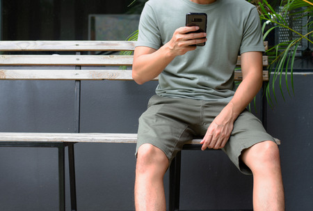 man sitting and play cellphoneの写真素材