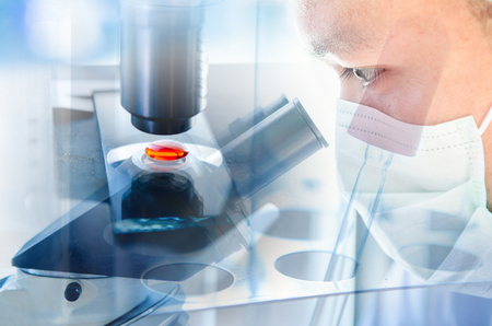Young scientist looking through a microscope in a laboratory. Young scientist doing some research.の写真素材