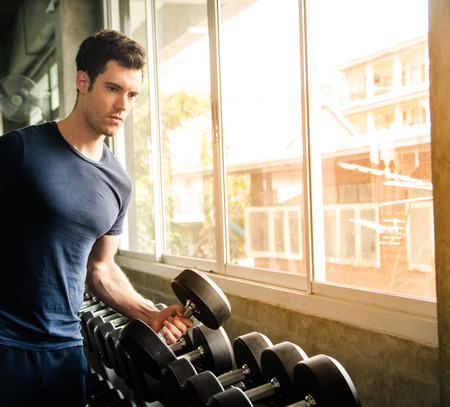 sport, fitness, bodybuilding, lifestyle and people concept - man exercising work out and flexing muscles in gymの写真素材