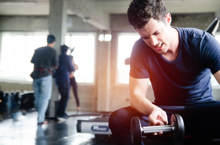 Bodybuilder working out with dumbbell weights at the gymの写真素材