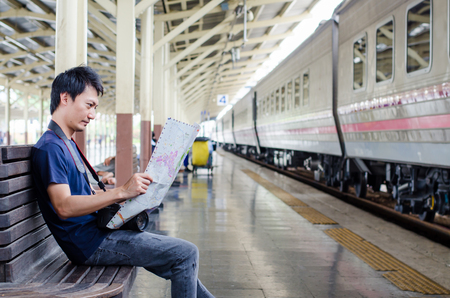 Young man traveler with map on street building backgroundの写真素材