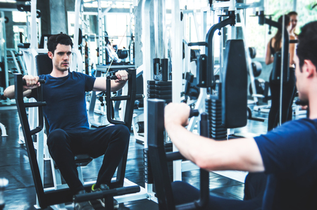 sport, fitness, bodybuilding, lifestyle and people concept - man exercising work out and flexing muscles in gymの写真素材