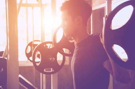 sport, fitness, bodybuilding, lifestyle and people concept - man exercising work out and flexing muscles in gymの写真素材