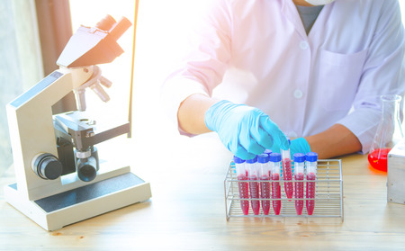 Young scientist looking through a microscope in a laboratory. Young scientist doing some research.の写真素材