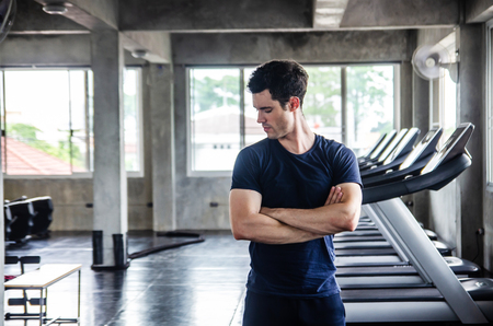 sport, fitness, bodybuilding, lifestyle and people concept - man exercising work out and flexing muscles in gymの写真素材