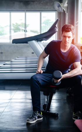 man pickup dumbell in gym . exercise with work out program for healthyの写真素材