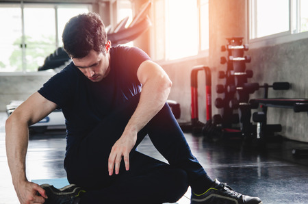 sport, fitness, bodybuilding, lifestyle and people concept - man exercising work out and flexing muscles in gymの写真素材