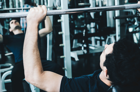 sport, fitness, bodybuilding, lifestyle and people concept - man exercising work out and flexing muscles in gymの写真素材