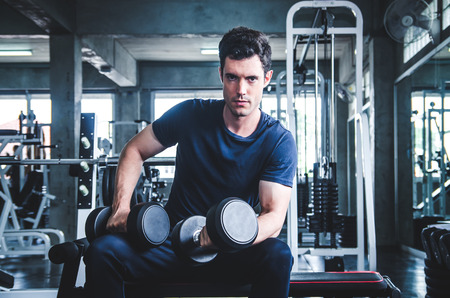 man pickup dumbell in gym . exercise with work out program for healthyの写真素材
