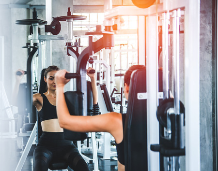 Woman exercise workout in gym fitness on machineの写真素材
