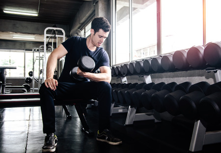 man pickup dumbell in gym . exercise with work out program for healthyの写真素材