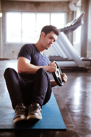 sport, fitness, bodybuilding, lifestyle and people concept - man exercising work out and flexing muscles in gymの写真素材